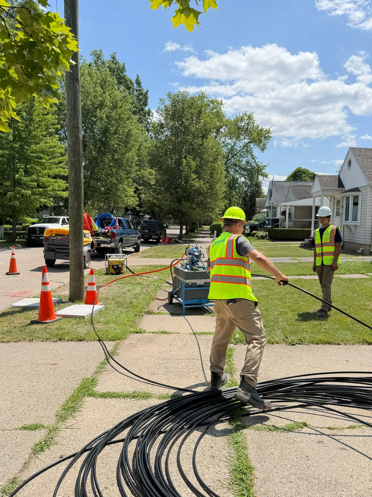 Infinite Energy Services crew paying fiber duct off a coil during a placement run